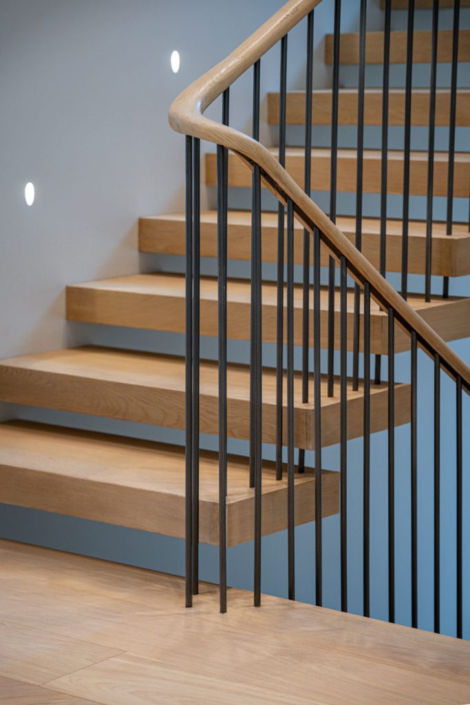 Zephyr floating stairs with a sleek steel structure, wooden treads, and minimalist railing for a modern interior.