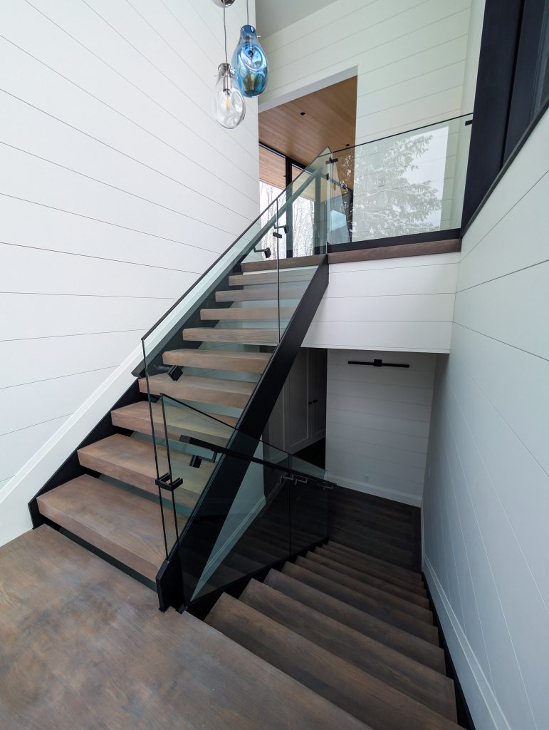 Astra double stringer staircase with a sleek, slim-profile steel structure, precision laser-cut design, and a modern floating aesthetic. Features optional glass railing integration for a clean, minimalist look.